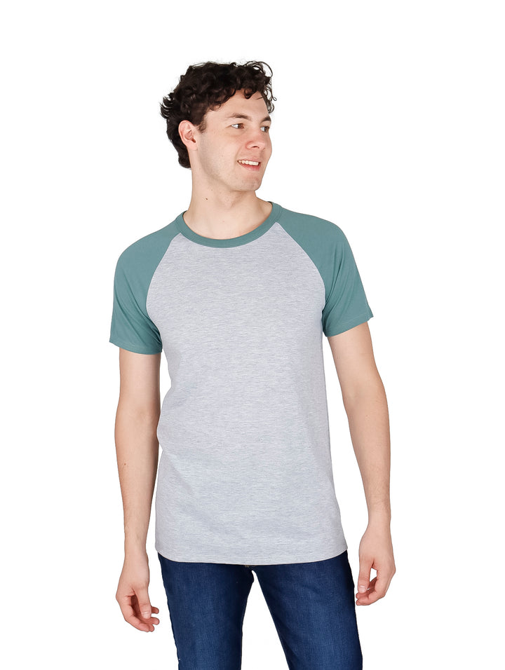 Hombre vistiendo playera manga corta estilo raglan en colores gris y verde hoja.