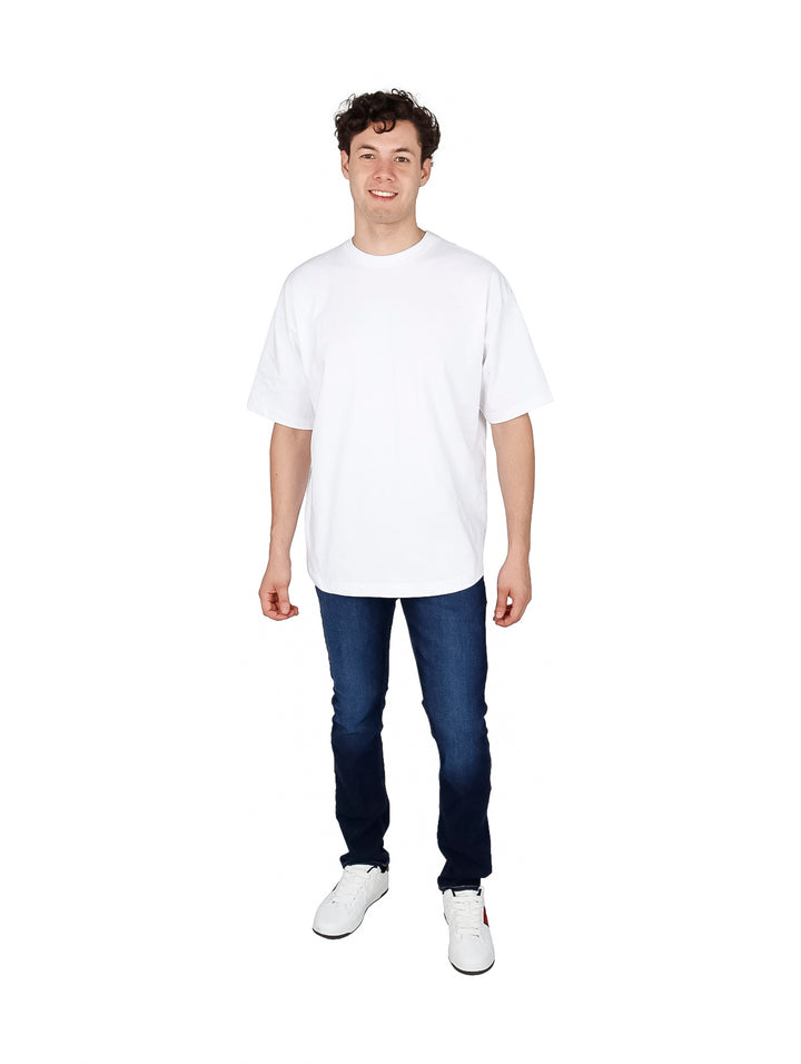Hombre vistiendo playera blanca oversize de manga corta y cuello redondo.