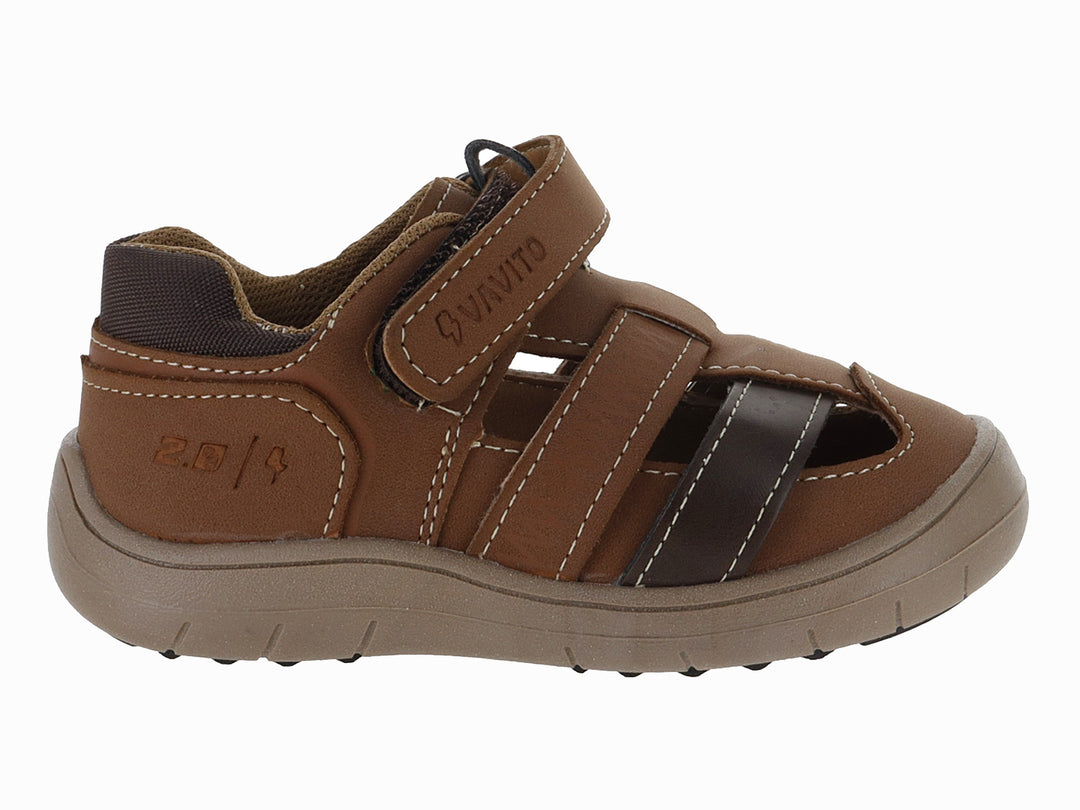 Sandalia infantil de cuero color cognac con punta cerrada y suela marrón.