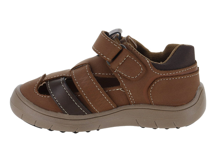 Sandalia infantil de cuero color cognac con punta cerrada y suela marrón.