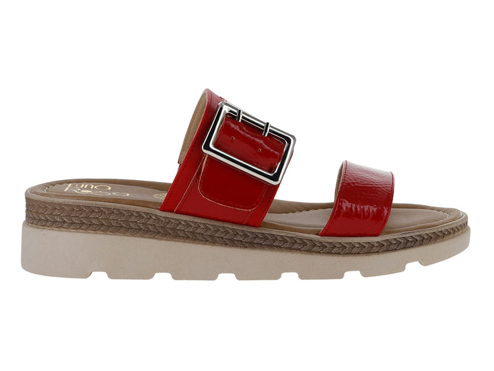 Sandalia roja de charol arrugado con hebilla plateada y suela beige de plataforma dentada.