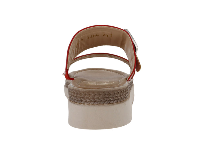 Sandalia roja de charol arrugado con hebilla plateada y suela beige de plataforma dentada.