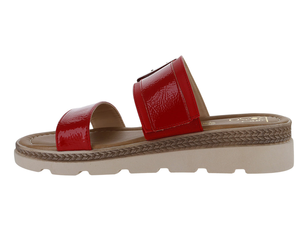 Sandalia roja de charol arrugado con hebilla plateada y suela beige de plataforma dentada.