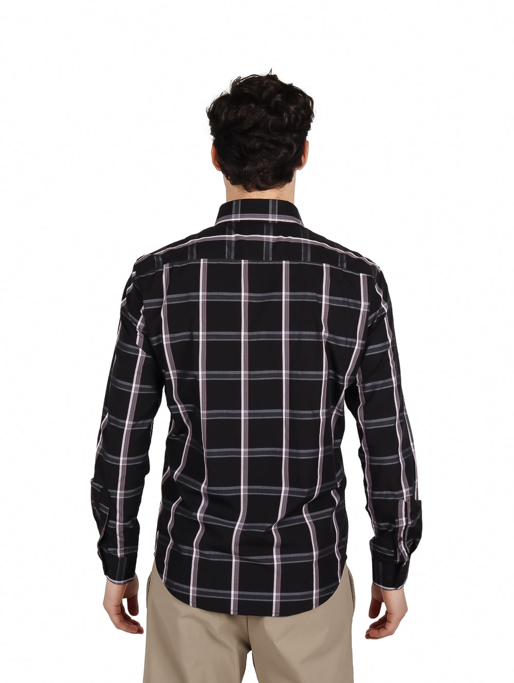 Hombre vistiendo camisa negra de manga larga con patrón de cuadros blancos y pantalones beige.