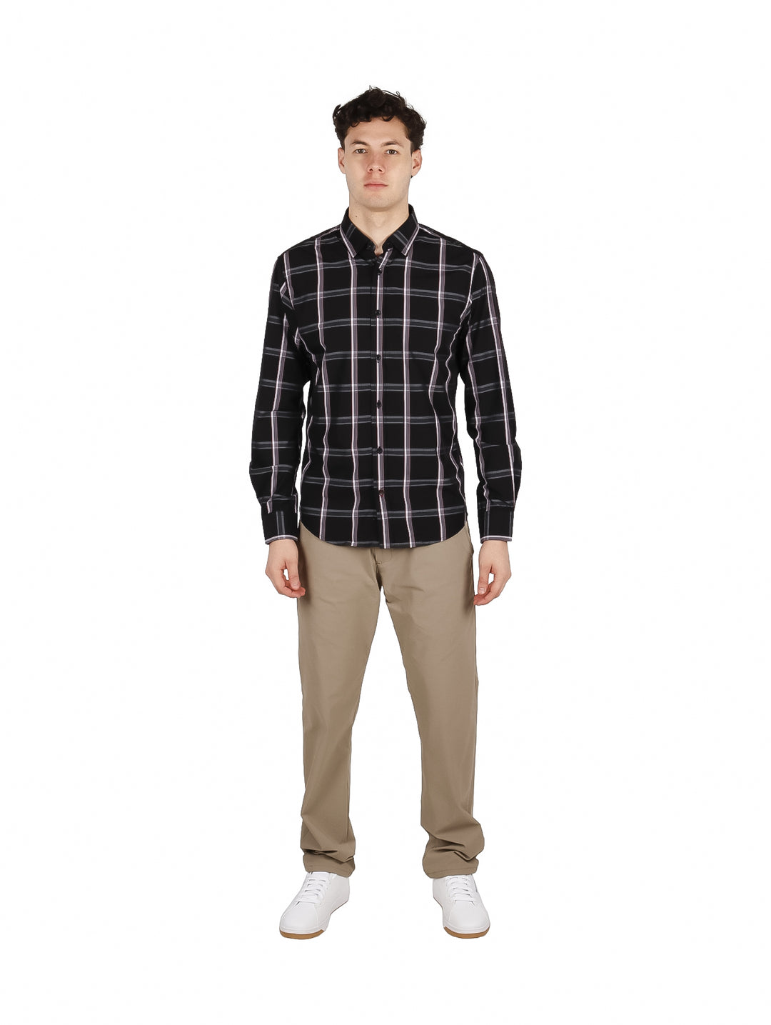 Hombre vistiendo camisa negra de manga larga con patrón de cuadros blancos y pantalones beige.