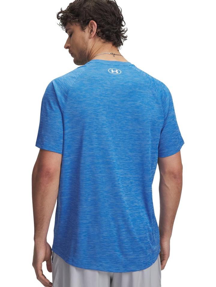 Hombre vistiendo una camiseta deportiva azul de manga corta con logotipo de Under Armour en el pecho.
