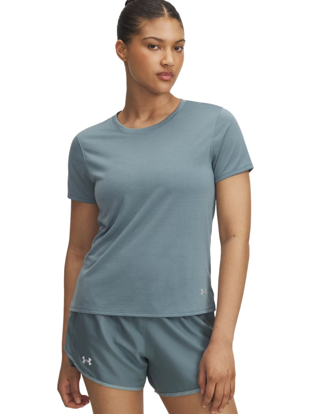Mujer vistiendo camiseta de manga corta y shorts deportivos de color azul de la marca Under Armour.