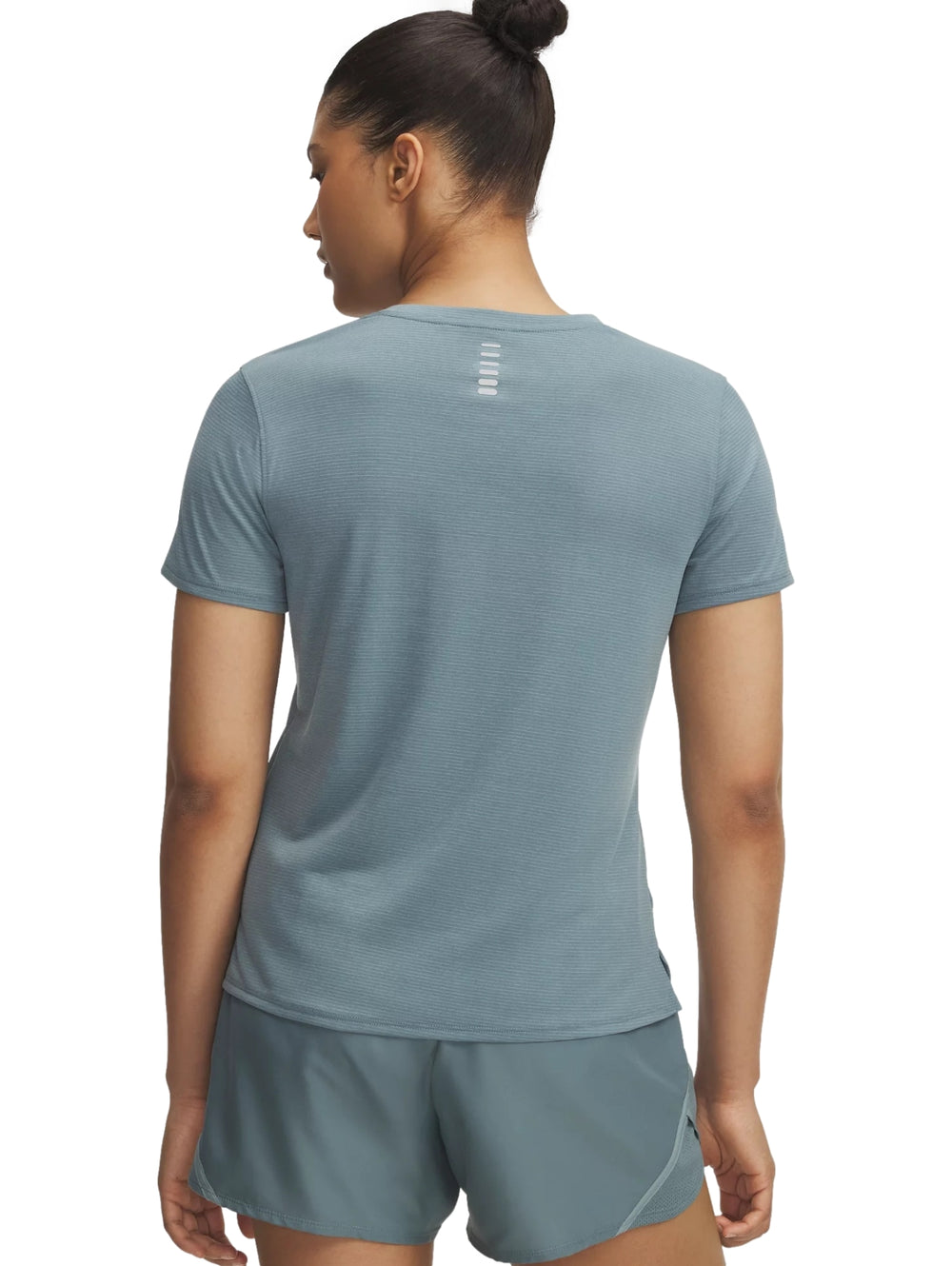 Mujer vistiendo camiseta de manga corta y shorts deportivos de color azul de la marca Under Armour.