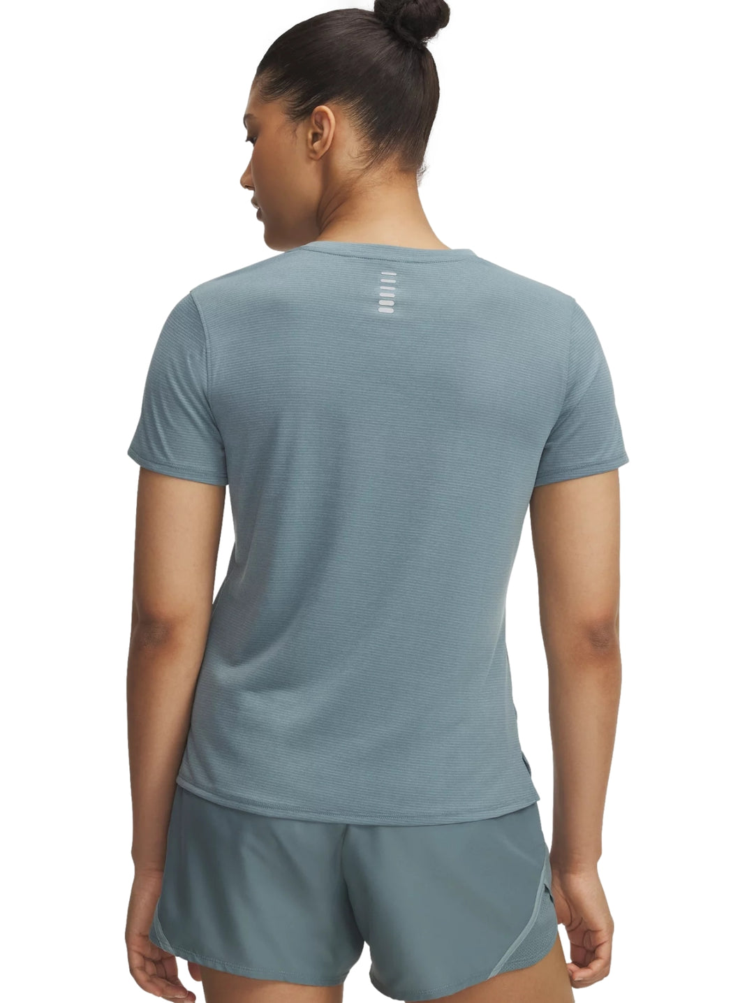 Mujer vistiendo camiseta de manga corta y shorts deportivos de color azul de la marca Under Armour.