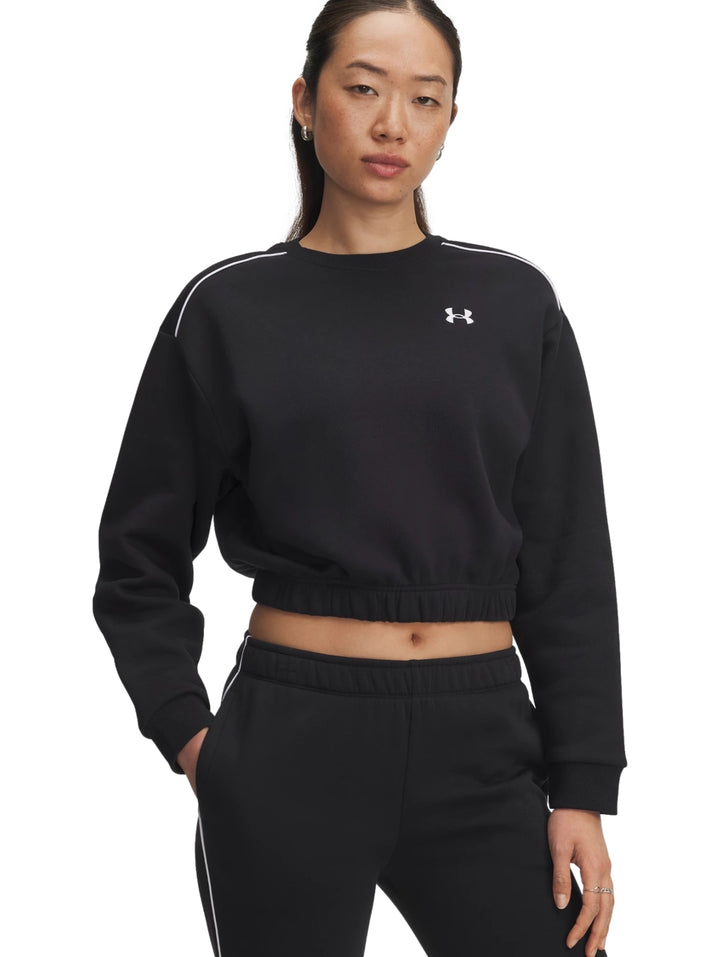 Mujer vistiendo sudadera corta negra con ribetes blancos y pantalones a juego de Under Armour.