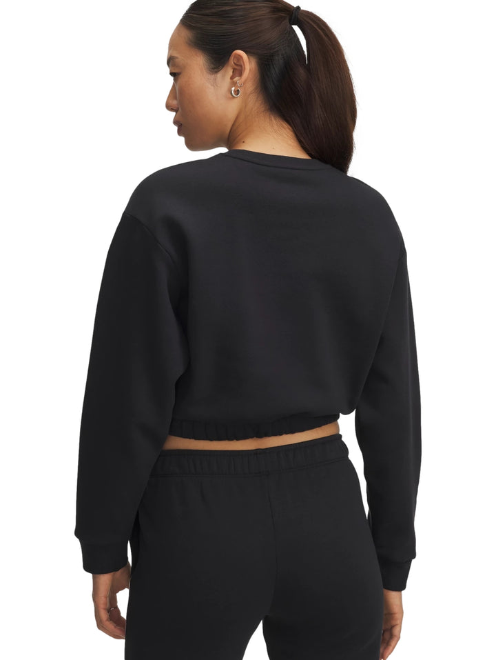 Mujer vistiendo sudadera corta negra con ribetes blancos y pantalones a juego de Under Armour.