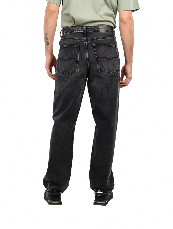 Hombre vistiendo pantalones jeans OGGI color negro lavado con estilo vintage y corte recto.