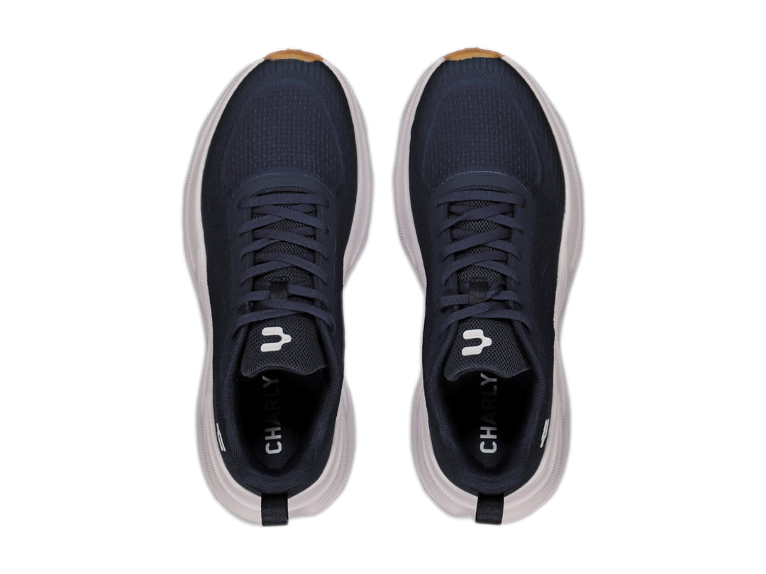 Tenis deportivos Charly en color negro con suela blanca y detalles en miel, diseño ligero para deporte.
