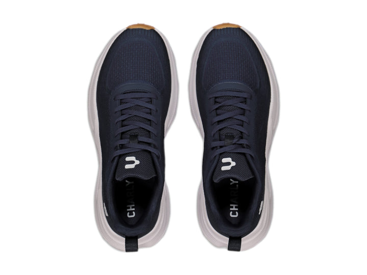 Tenis deportivos Charly en color negro con suela blanca y detalles en miel, diseño ligero para deporte.