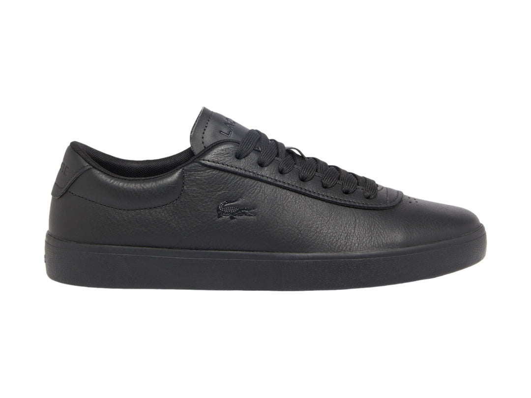 Tenis Lacoste color negro de cuero granulado con suela plana y cordones.