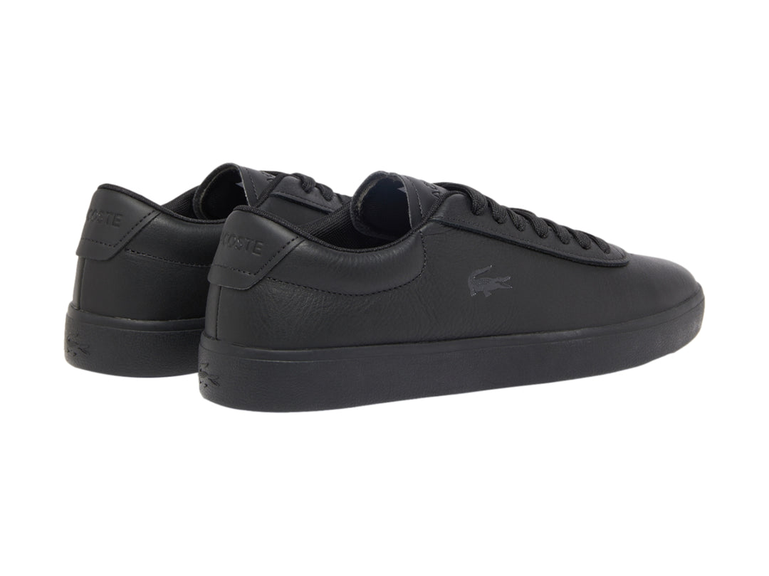 Tenis Lacoste color negro de cuero granulado con suela plana y cordones.