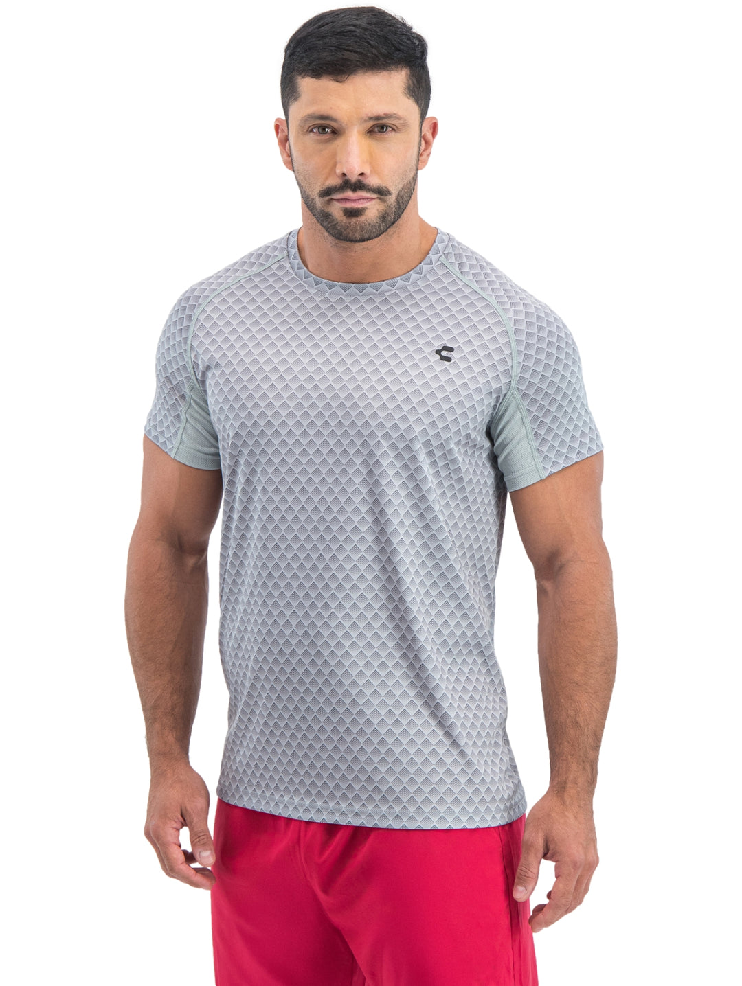 Hombre vistiendo playera deportiva de manga corta color gris claro con patrón geométrico.