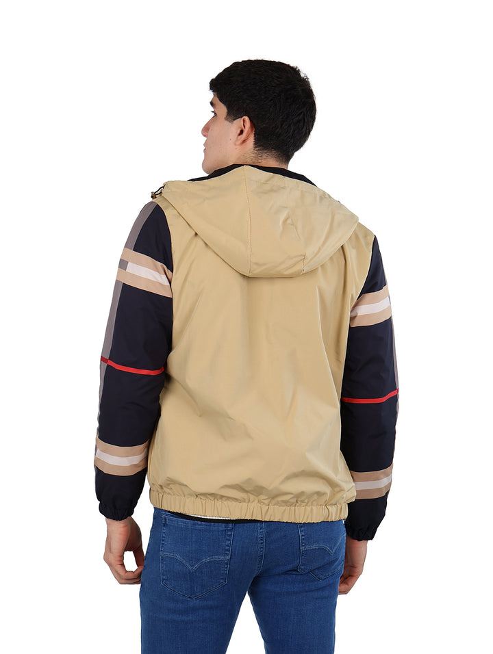 Hombre vistiendo chamarra Pavini color beige y negro con capucha y detalles laterales en las mangas.