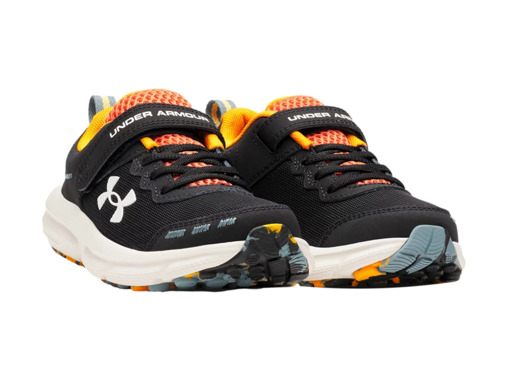 Tenis deportivos Under Armour para niño en color negro con detalles naranja y suela blanca.