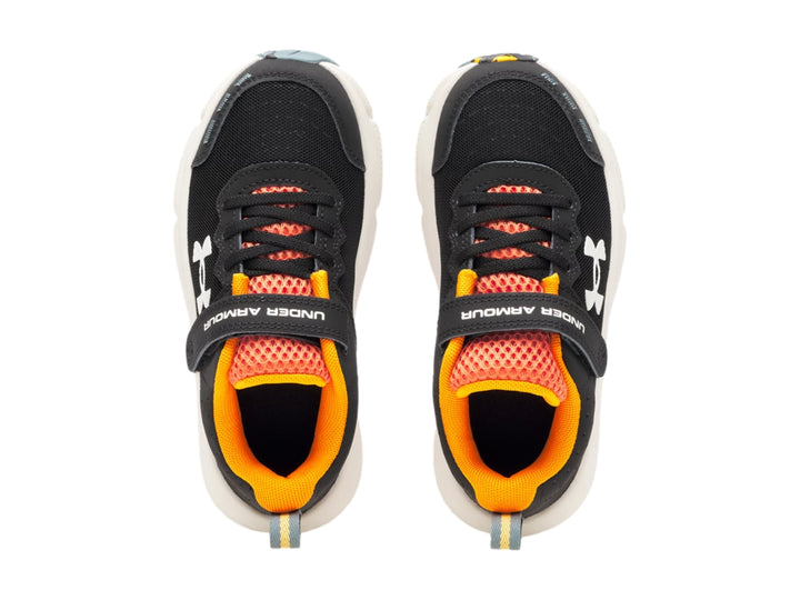 Tenis deportivos Under Armour para niño en color negro con detalles naranja y suela blanca.
