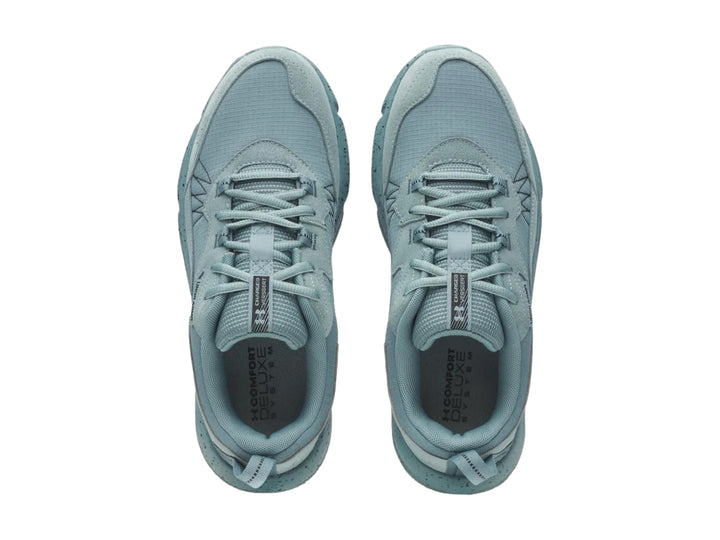 Tenis deportivos Under Armour color azul claro con suela gruesa moteada y malla transpirable.