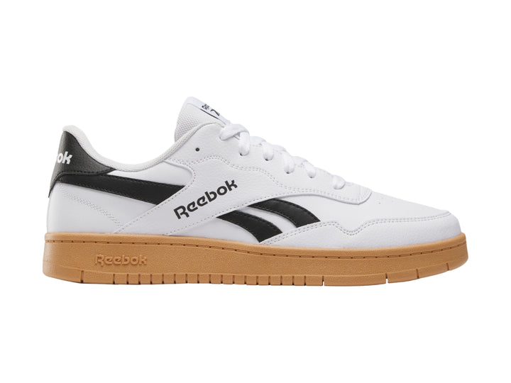 Tenis Reebok blancos con detalles en negro y suela de goma color café.