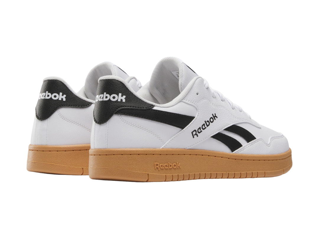 Tenis Reebok blancos con detalles en negro y suela de goma color café.