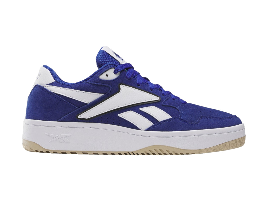 Tenis Reebok azul y blanco con suela de goma color miel, vista lateral.