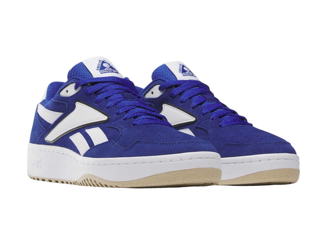 Tenis Reebok azul y blanco con suela de goma color miel, vista lateral.