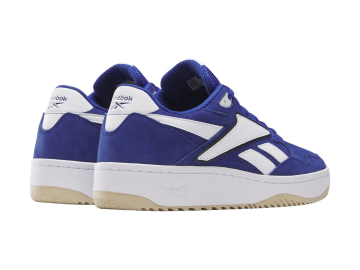 Tenis Reebok azul y blanco con suela de goma color miel, vista lateral.