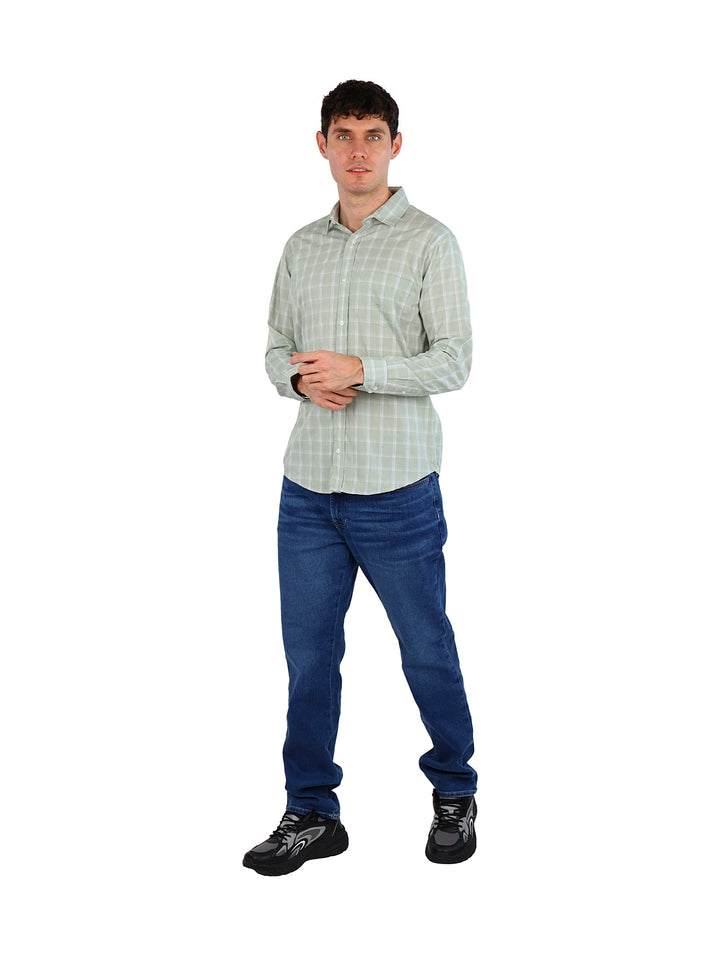 Hombre vistiendo una camisa de manga larga color menta con patrón de cuadros y pantalones azules.