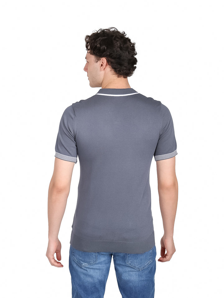 Hombre vistiendo playera polo tejida color gris con detalles blancos en cuello y mangas.
