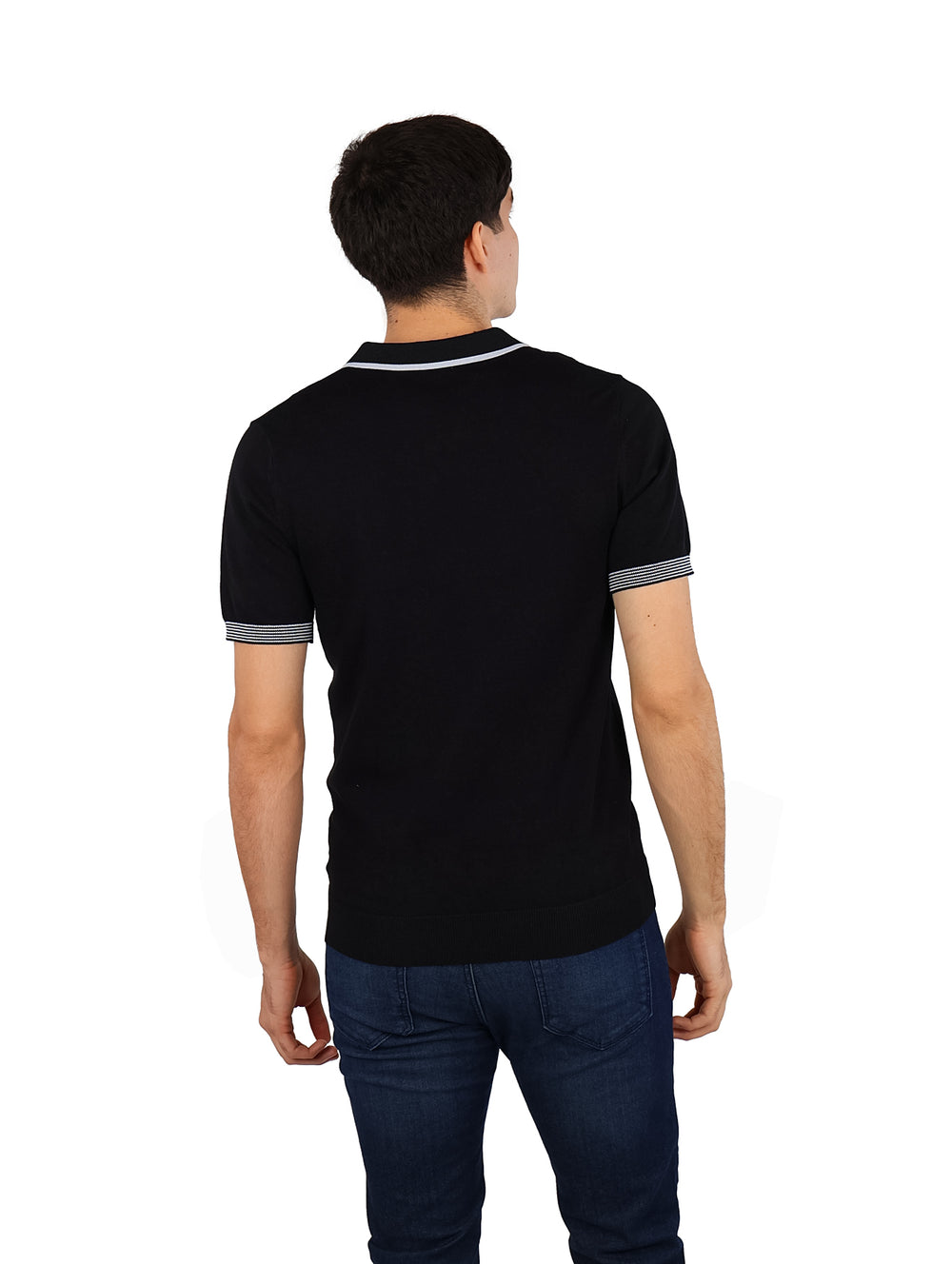 Hombre vistiendo playera polo tejida color negro con detalles blancos en el cuello y los bordes de las mangas.