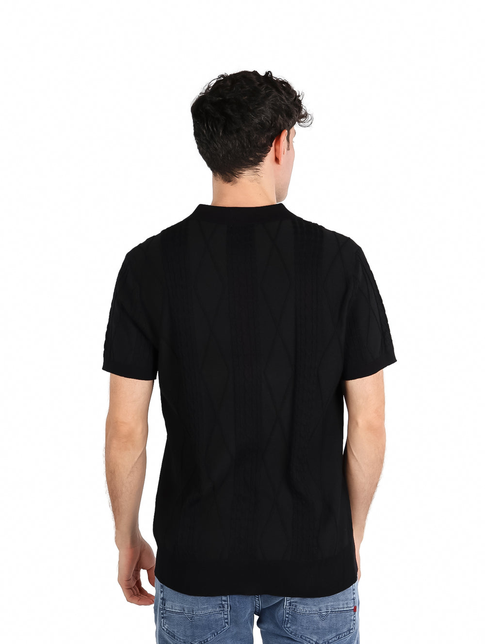 Hombre vistiendo una playera polo tejida de color negro con botones frontales y manga corta.