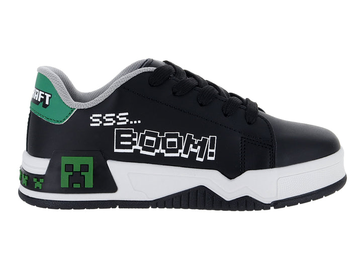 Tenis negros para niño con suela blanca y detalles decorativos en verde y blanco.