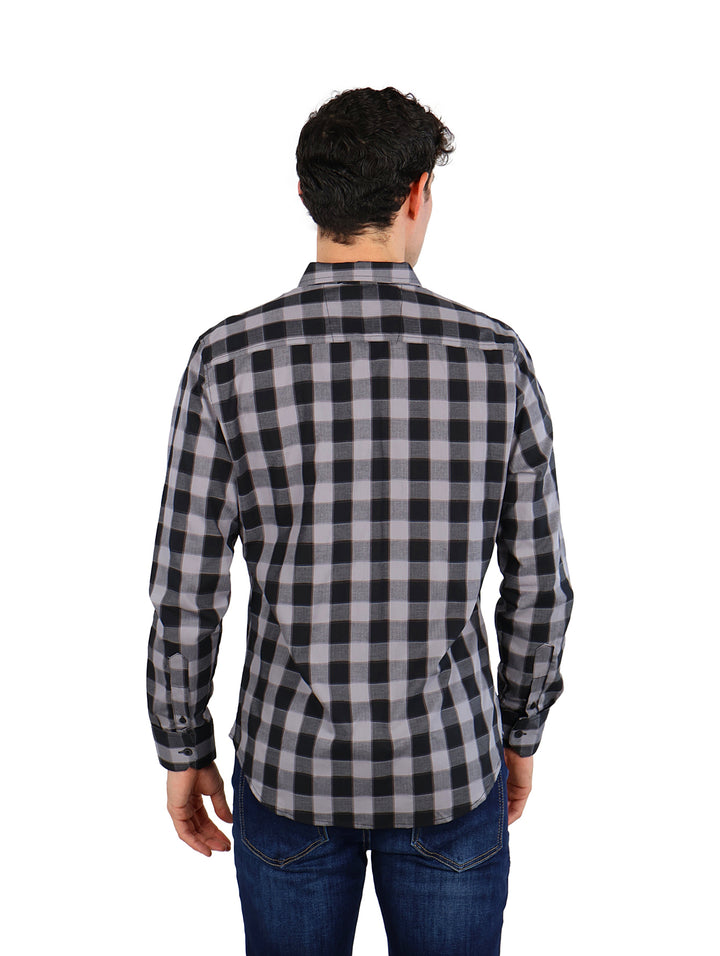 Hombre vistiendo camisa de manga larga con patrón de cuadros en colores negro y gris.