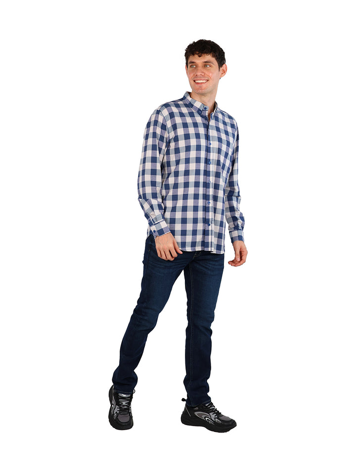 Hombre vistiendo una camisa de cuadros azul cielo y blanco de manga larga y pantalones vaqueros azules.