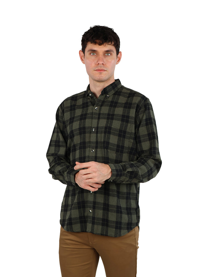 Hombre vistiendo camisa de cuadros en colores verde y negro.