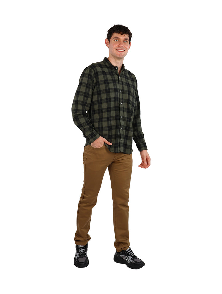 Hombre vistiendo camisa de cuadros en colores verde y negro.
