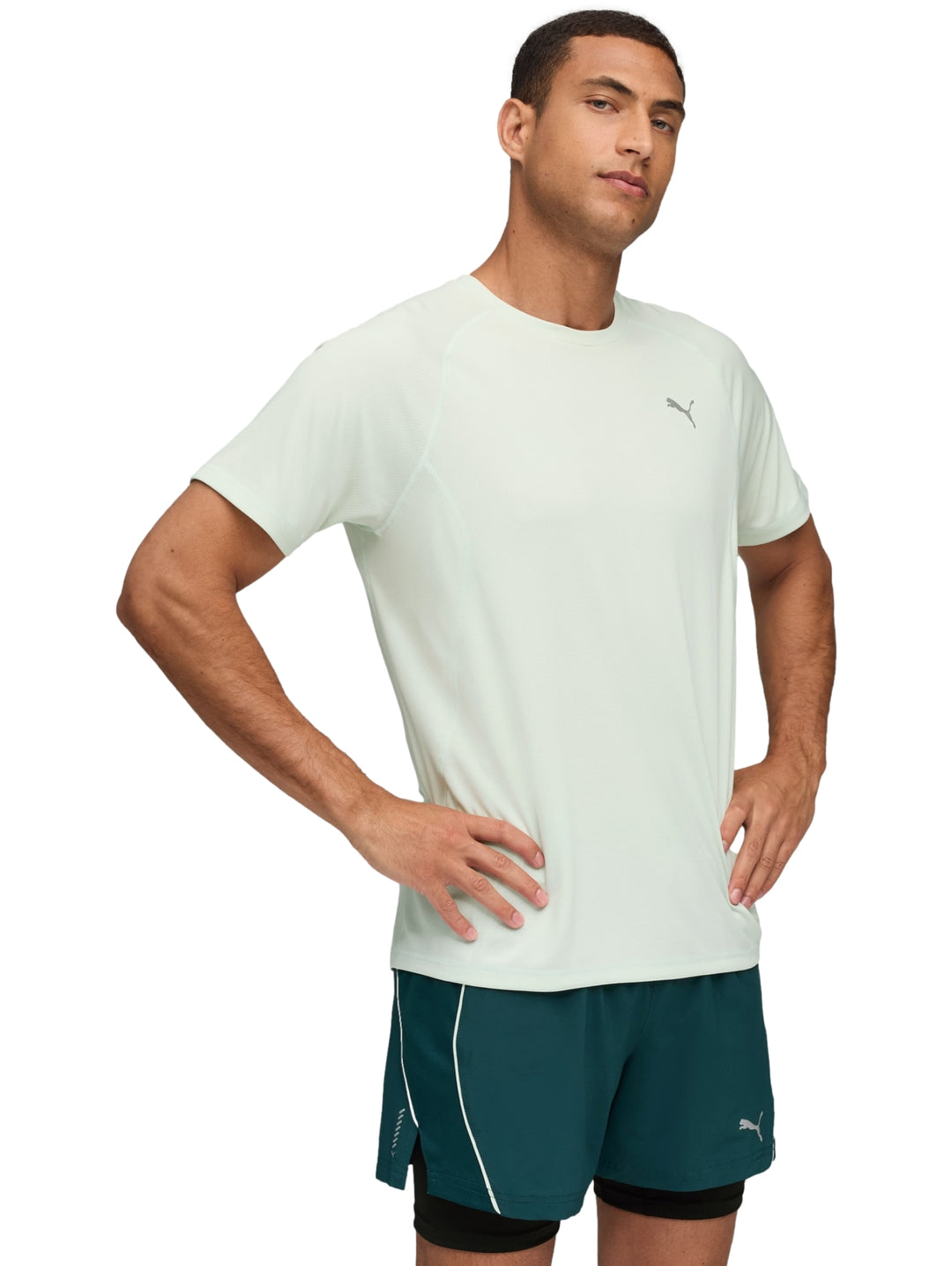 Hombre usando camiseta deportiva PUMA color verde claro Sage Frost y shorts deportivos verdes.