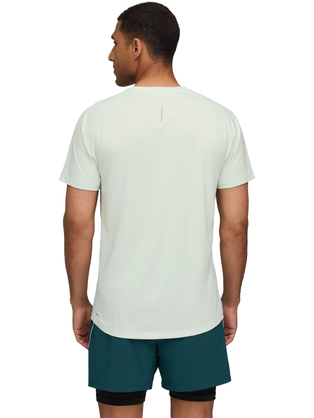 Hombre usando camiseta deportiva PUMA color verde claro Sage Frost y shorts deportivos verdes.