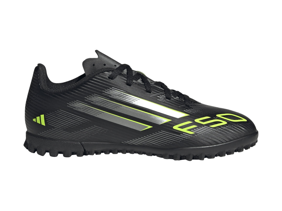 Tenis de fútbol Adidas F50 color negro con rayas plateadas y detalles en amarillo limón para niños.