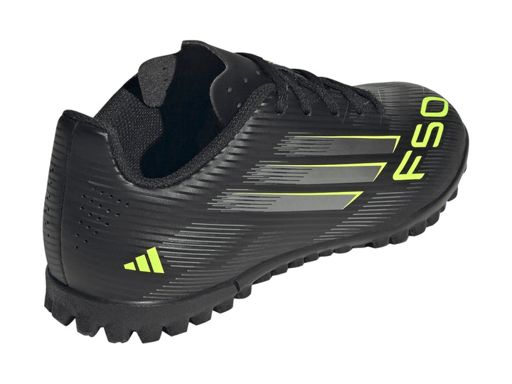 Tenis de fútbol Adidas F50 color negro con rayas plateadas y detalles en amarillo limón para niños.