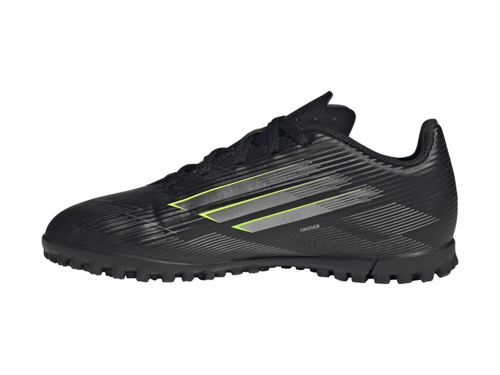 Tenis de fútbol Adidas F50 color negro con rayas plateadas y detalles en amarillo limón para niños.