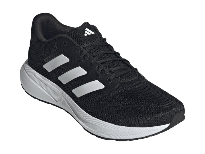 Tenis deportivos Adidas color negro con franjas y suela blanca.