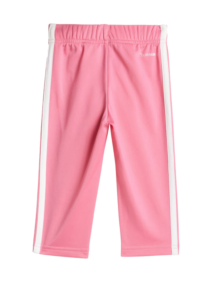 Conjunto deportivo Adidas rosa para niña con franjas blancas laterales y banda blanca en la chaqueta.