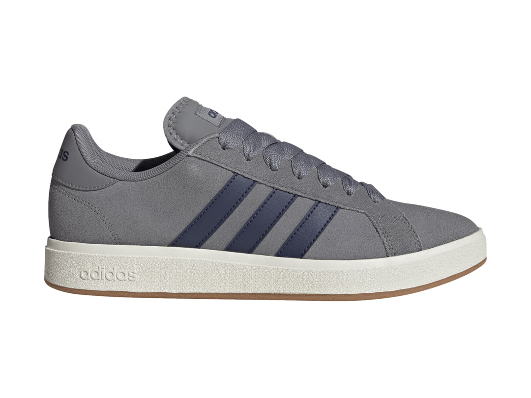 Tenis Adidas color gris con franjas azules y suela blanca.