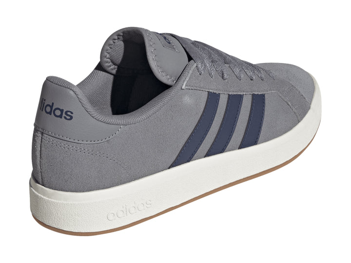Tenis Adidas color gris con franjas azules y suela blanca.