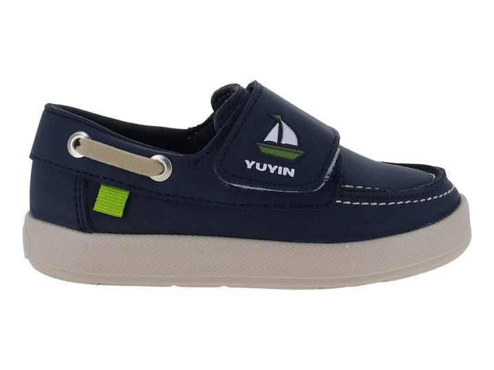 Zapato náutico infantil color azul marino con suela beige y pequeño detalle verde.