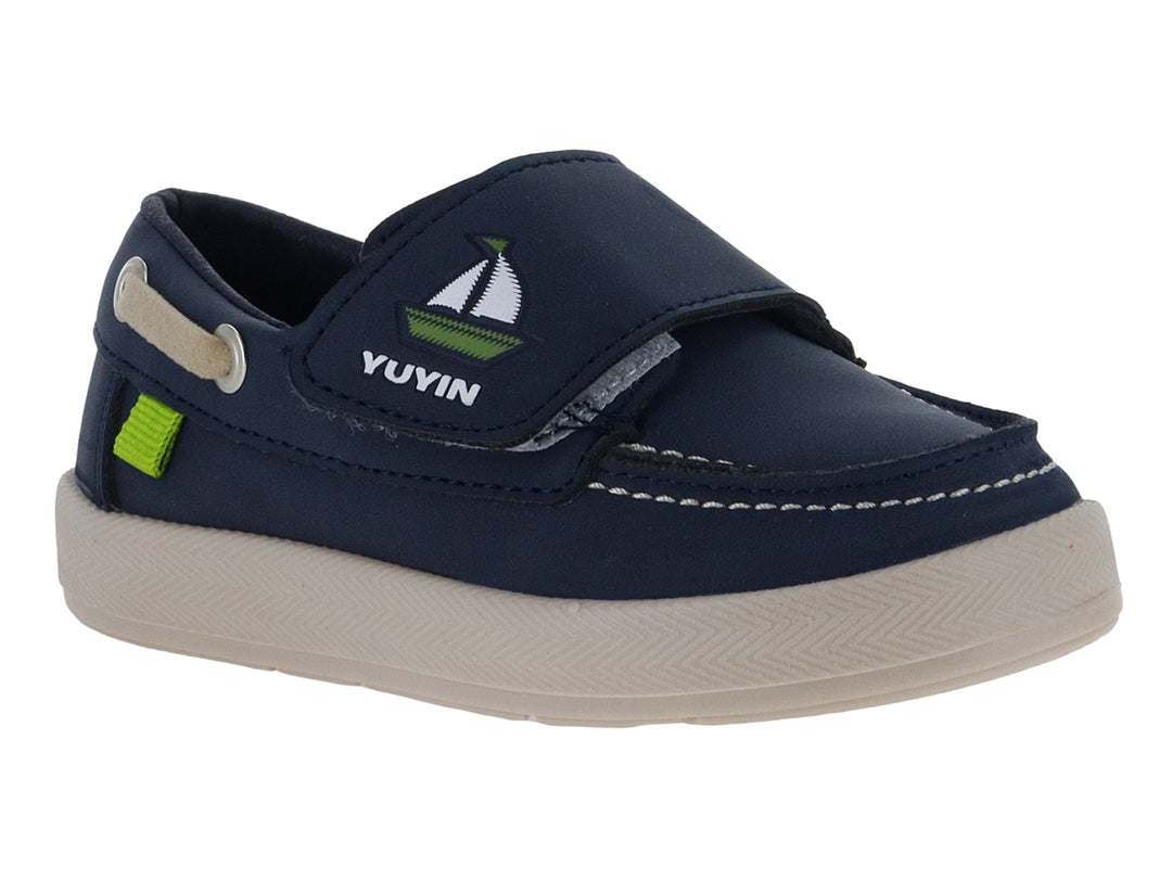 Zapato náutico infantil color azul marino con suela beige y pequeño detalle verde.